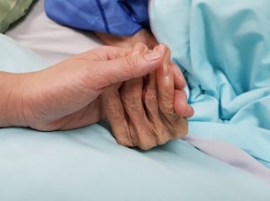 adult child holding elderly parent's hand